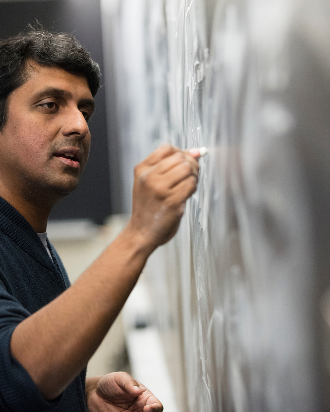 Vinod Vaikuntanathan writing on chalkboard