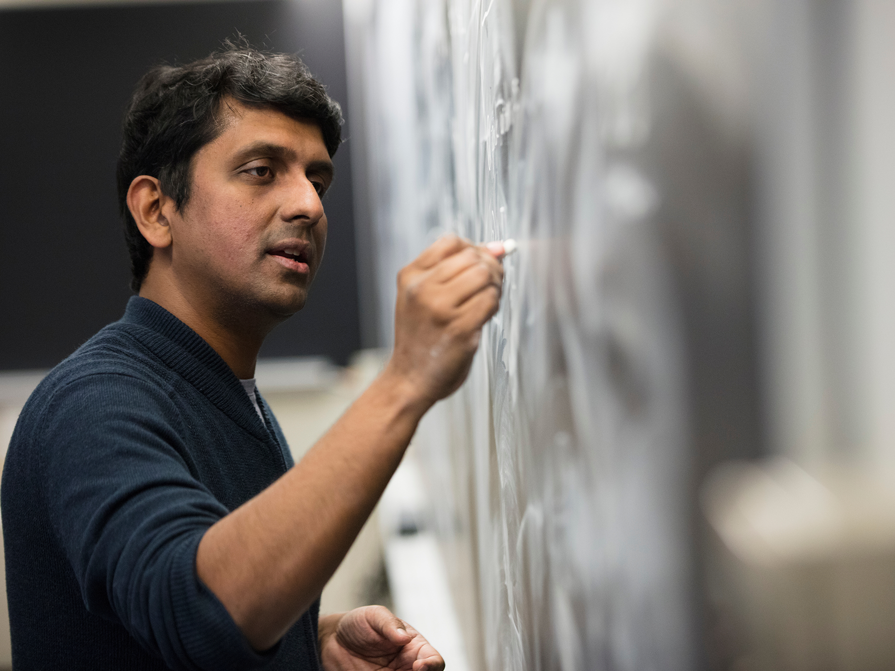 Vinod Vaikuntanathan writing on chalkboard