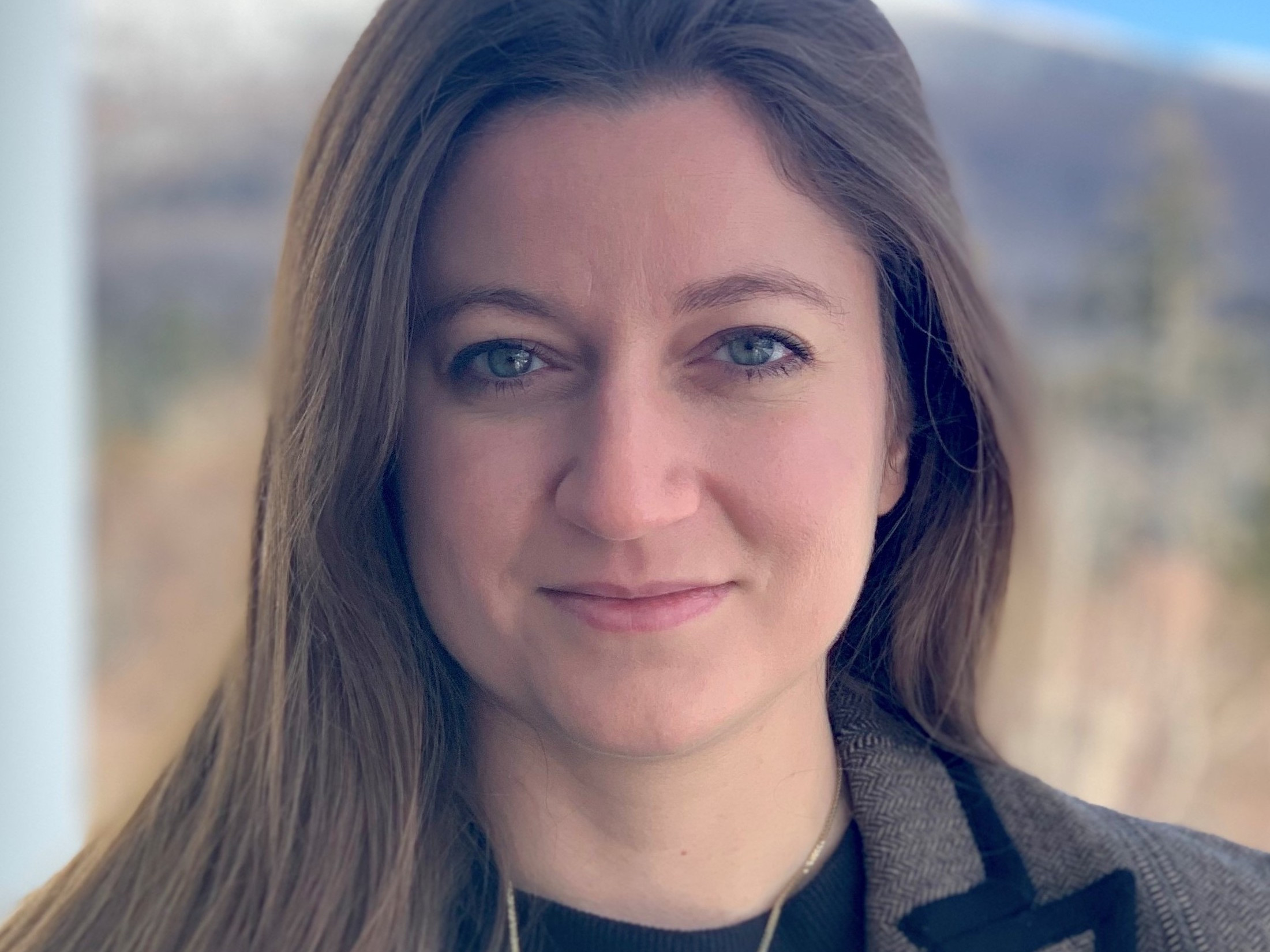 photo of Jelena Notaros in brown blazer in front of mountain view