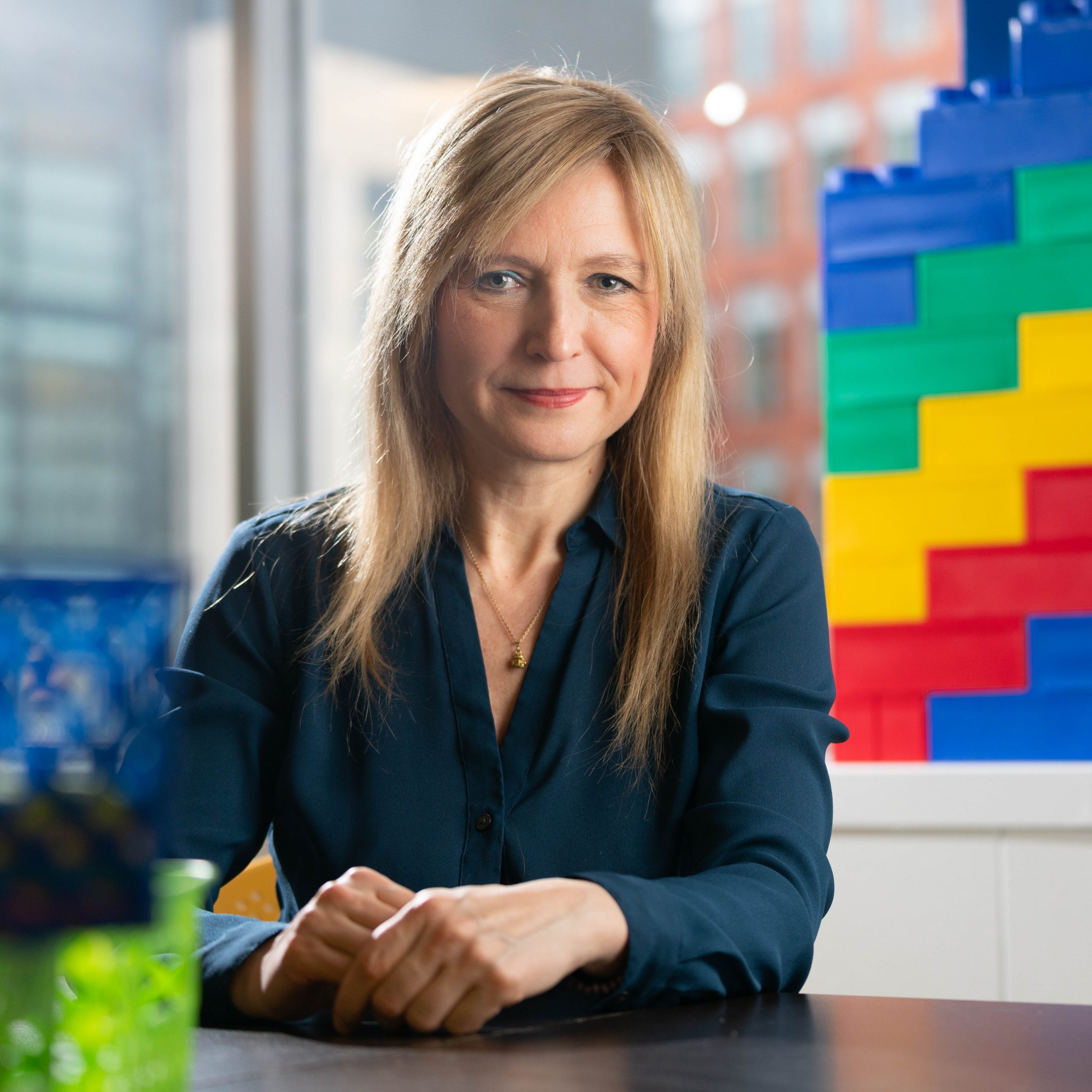 photo of Aude Oliva seated in front of large building blocks