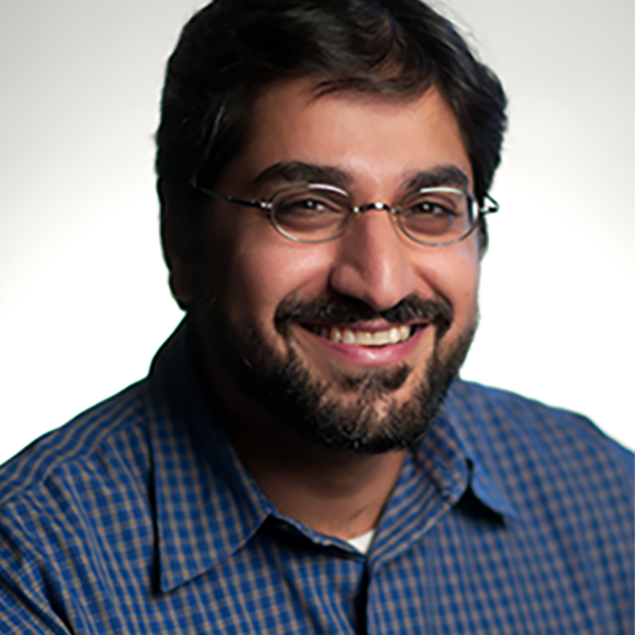photo of rajeev ram in blue plaid shirt with white background