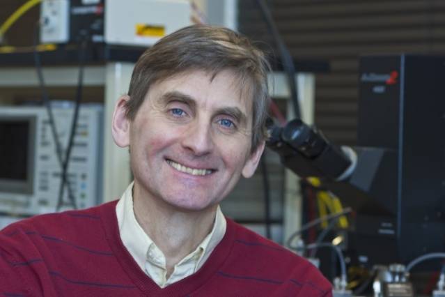photo of MIT Professor Jesus del Alamo in front of microscope