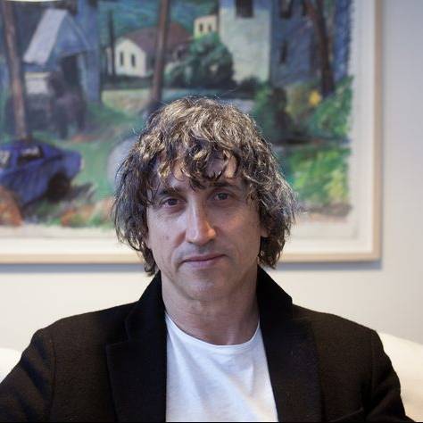 photo of nir shavit seated in front of painting