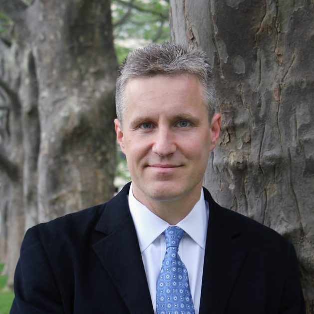 photo Martin Bazant standing by trees in dark suit