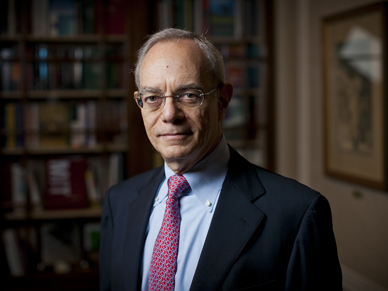MIT President Rafael Reif in his office standing in front of bookshelves