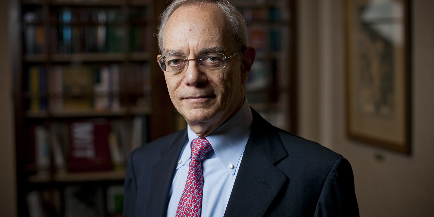 MIT President Rafael Reif in his office standing in front of bookshelves