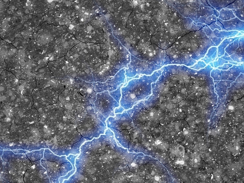 A streak of blue lightning, representing energy, spreads horizontally across a textured cement surface.