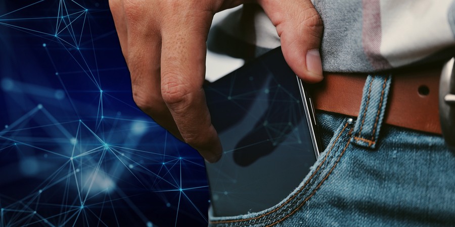 A cell phone peeks out from the pocket of a person wearing jeans, a belt, and a plaid shirt. In the background and on the cell phone’s screen are stylized connected nodes representing a neural network.