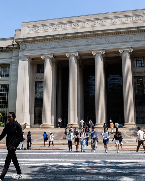 People cross Mass Ave, with the columns and steps off Lobby 7 in background.