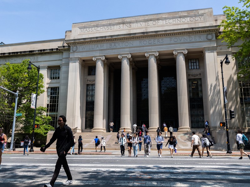 People cross Mass Ave, with the columns and steps off Lobby 7 in background.