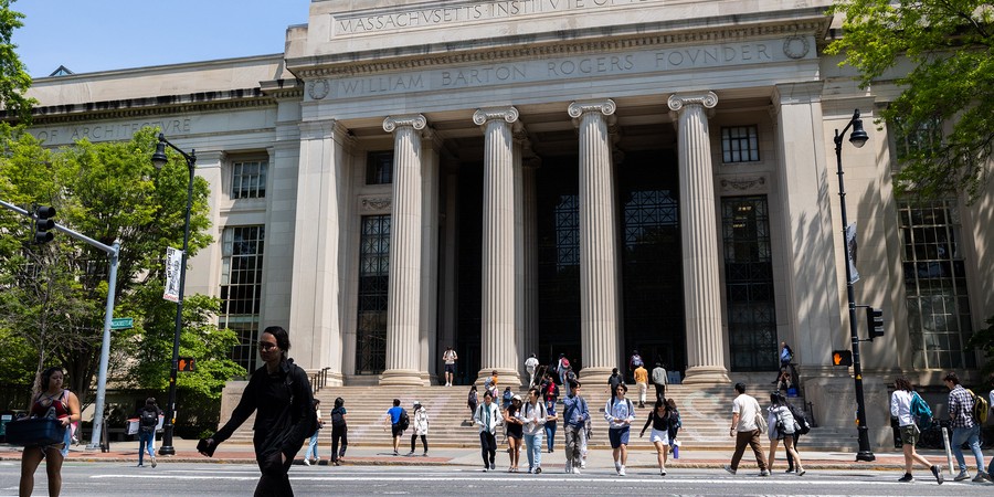People cross Mass Ave, with the columns and steps off Lobby 7 in background.