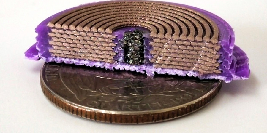 On top of a quarter sits a disc-like device chopped in half to show the interior: purple plastic is on outside, eight stacks of coiled copper-colored rods; and in the middle is a black substance.