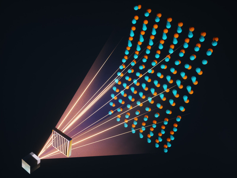 Graphic showing light emanating from a cubic crystal and passing through a material with an array of square holes. A lattice of atoms appears on the other side