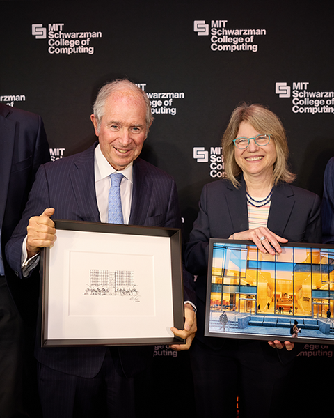 Dan Huttenlocher, Stephen Schwarzman, Sally Kornbluth, and L. Rafael Reif stand against a backdrop featuring the MIT Schwarzman College of Computing logo. Kornbluth holds a framed photo of a glass building, while Schwarzman holds a framed pencil drawing of the same building.