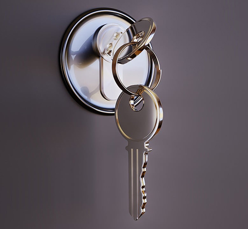 close up image of keys in lock on grey door