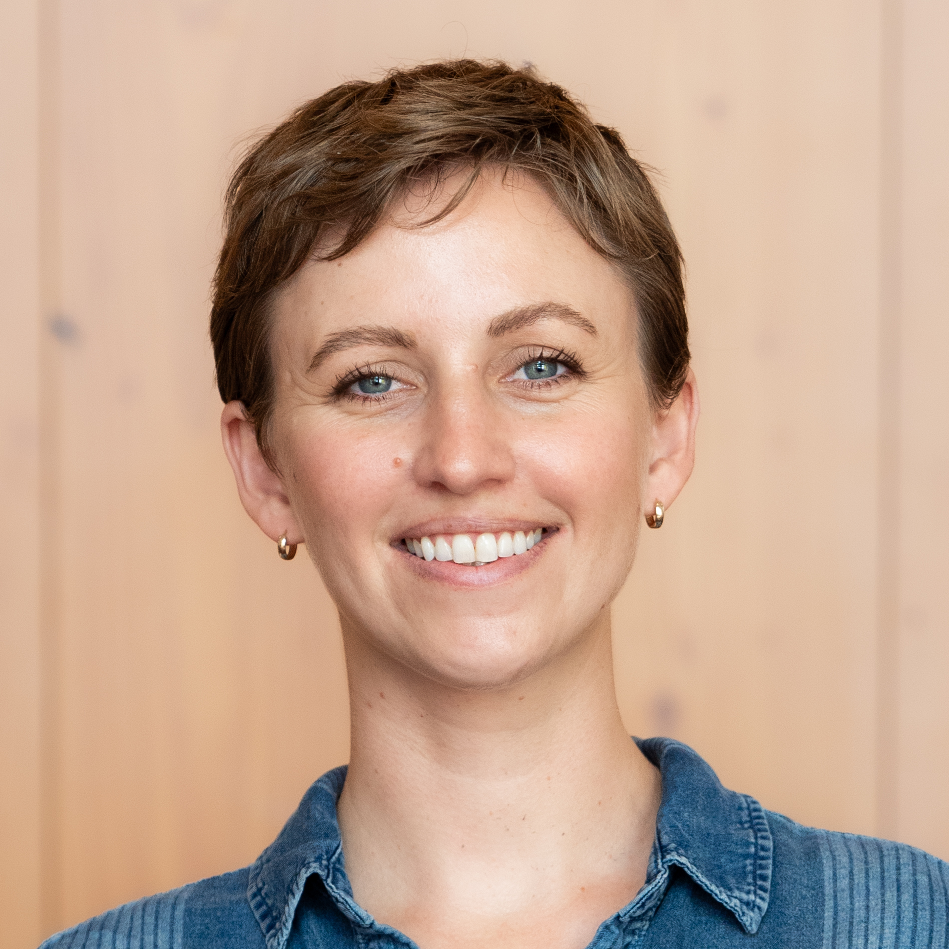 woman wearing blue shirt in front of blurred woodgrain background